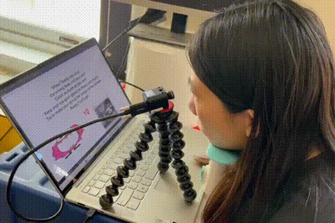 Participant using an eye-facing event camera beside a laptop during an eye-tracking demonstration.